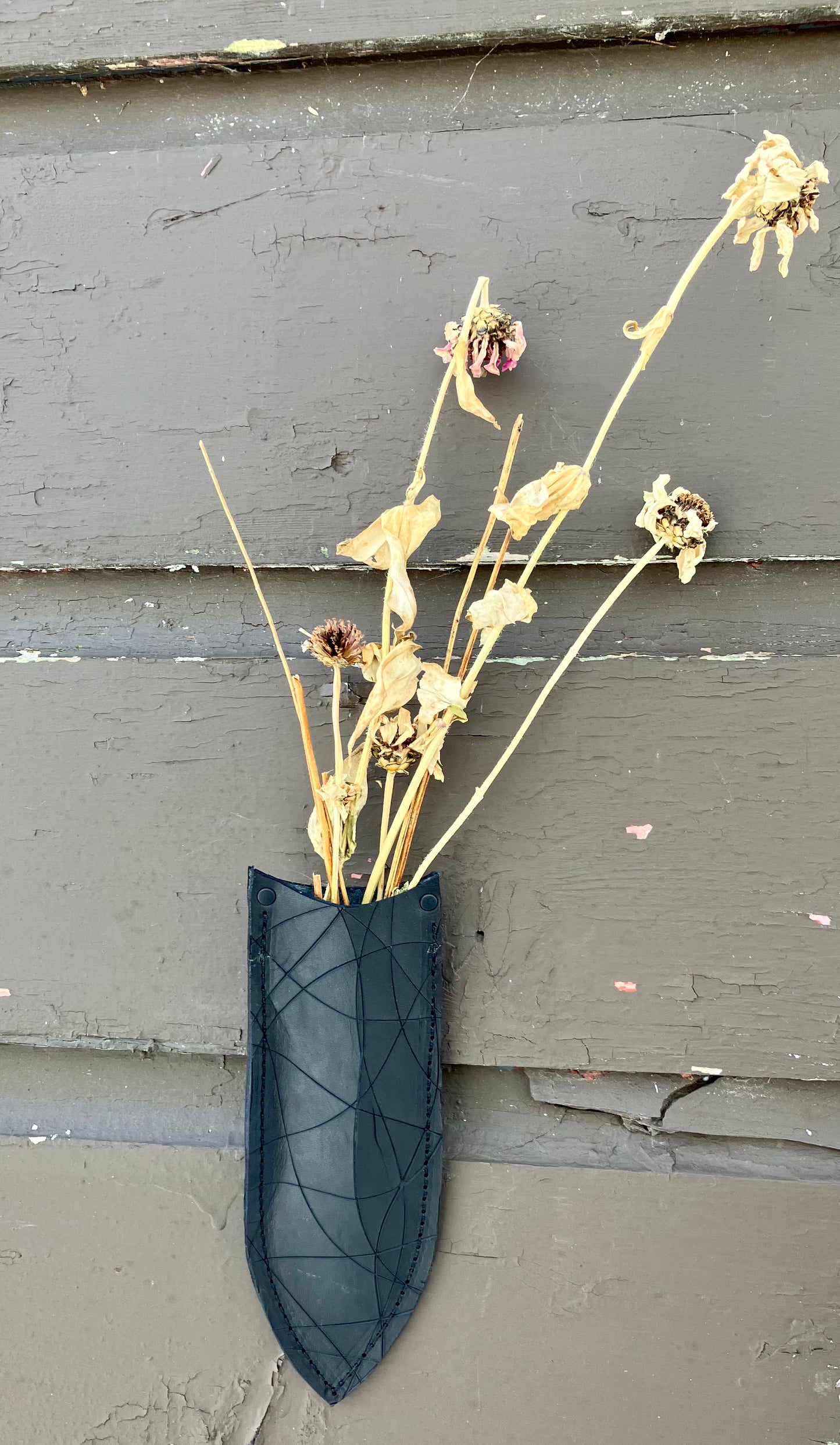 a wilder leather handcrafted leather air vase is perfect for dried flowers or other things you wish to suspend on the wall.