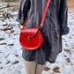 red slash embossed handmade leather bag with crossbody strap and pocket by Wilder Leather. 