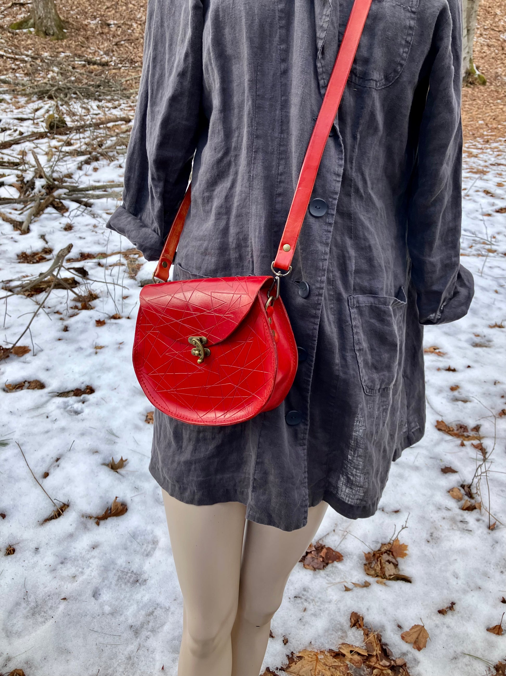 red slash embossed handmade leather bag with crossbody strap and pocket by Wilder Leather. 