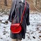 red slash embossed handmade leather bag with crossbody strap and pocket by Wilder Leather. 