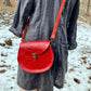 red slash embossed handmade leather bag with crossbody strap and pocket by Wilder Leather. 